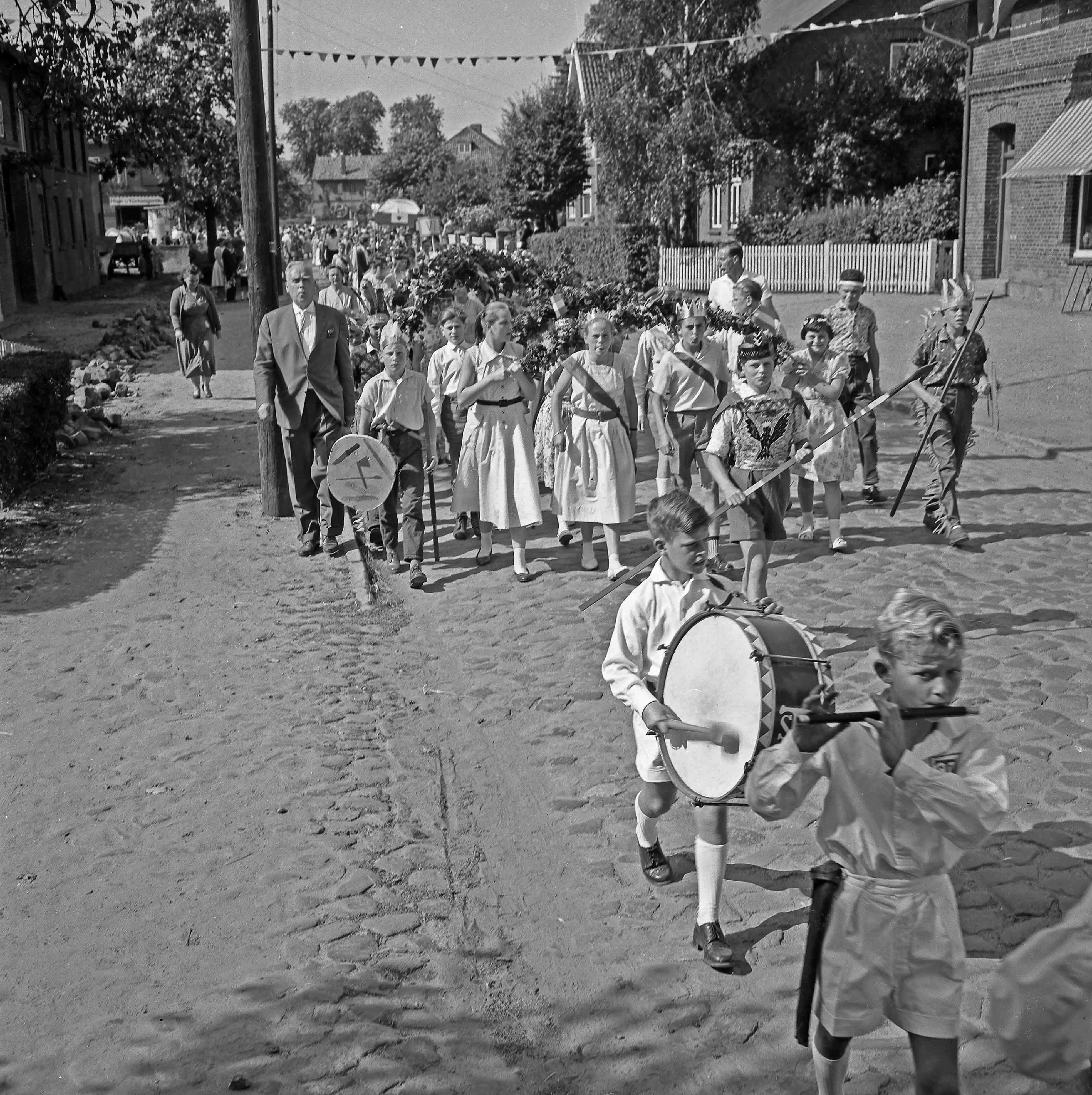 Kindervogelschießen: Umzug: vorne Schüler-Spielmannszug des Turn- und Sportvereins TSV Bargteheide: Bildmitte Schüler verkleidet als Ritter, Indianer: dahinter Schüler mit Blumenbögen, 1958