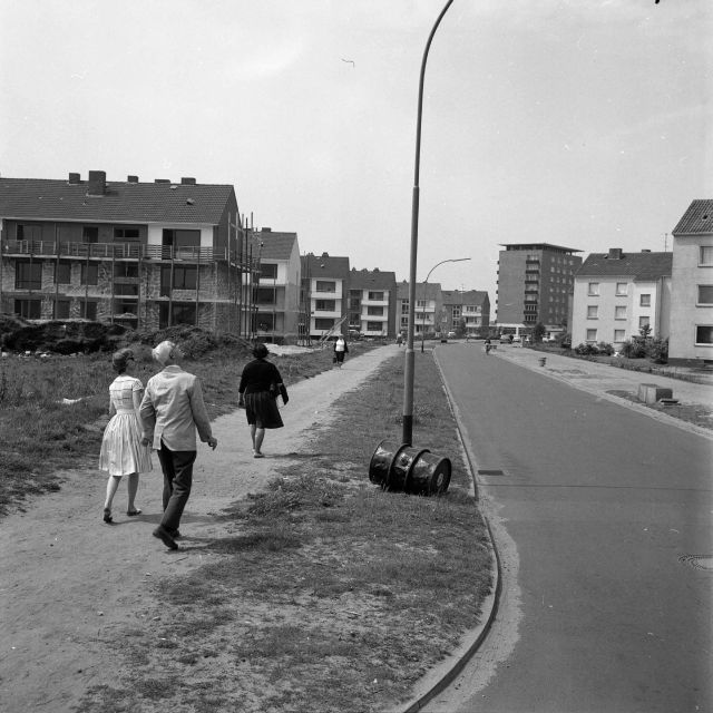 Norderstedt: Harksheide: Stonsdorfer Weg: links Baustelle eines Wohngebäudes, dahinter und rechts weitere Wohngebäude, im Hintergrund das Rathausgebäude: Blick von Osten, 1963